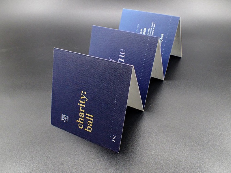 Accordion-fold charity ball invitation in navy and gold