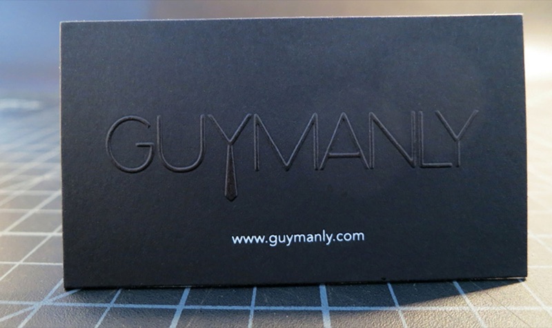 Embossed logo detail on black paper business card