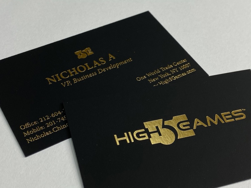 Gold foil stamped business cards on thick black paper