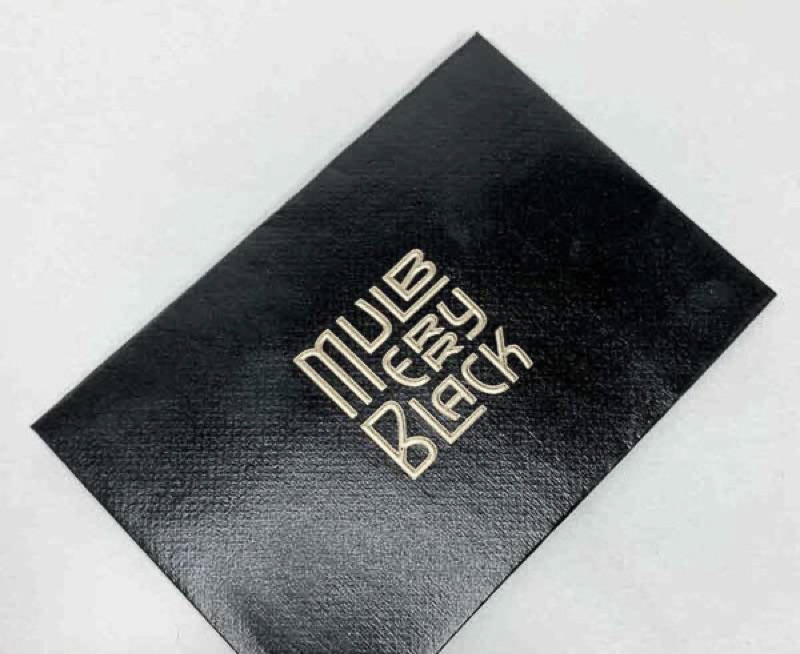 Raised gold ink on black paper envelope