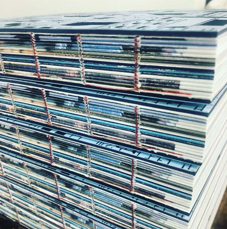 Stack of sewn book signatures showing thread